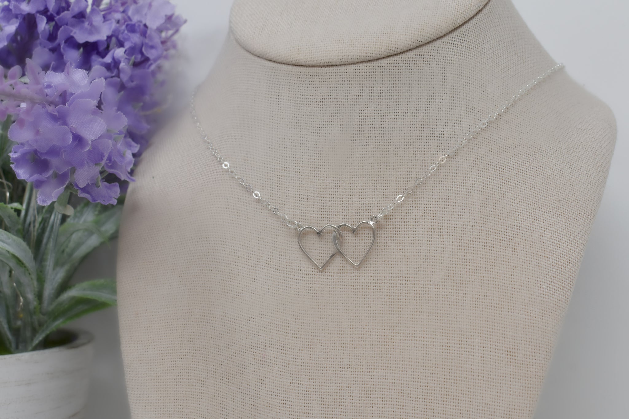 Two Interlocking Hearts in Sterling Silver Suspended on an 18 Inch Sterling Silver Split Chain.
